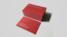 Stapel bordeauxroter Visitenkarten mit silberner Heißfolienprägung des Namens „Simone Westphal“ und weiß gedruckten Kontaktdaten auf der Rückseite.