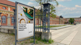 Plakat im öffentlichen Raum als Mock-up für das Kreativquartier Potsdam. Das Design kombiniert eine moderne Typografie mit einem Food-Fotografie-Motiv. Die Headline „Für Gaumen knallen hier Geschmacksknospen.“ spielt mit Sprache und betont das kulinarische Angebot des Quartiers. Im Hintergrund ist eine historische Gebäudeanlage in Potsdam zu sehen.